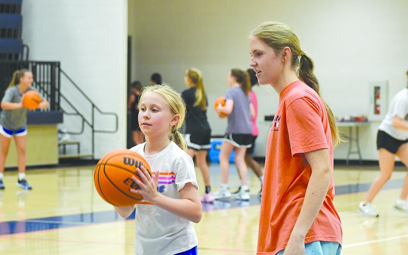 HCHS’ Tessa Murdock offers pointers to camper Harper Allen. LANG STOREY/Staff