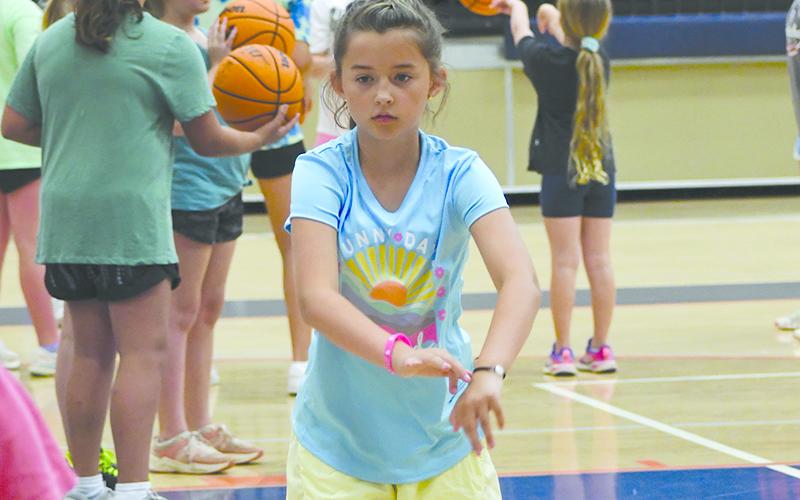 Camper Ruby Nicholson works on her bounce pass at camp Monday. LANG STOREY/Staff