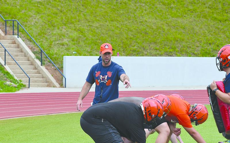 Coach Tip Johnson coaches up the offensive line Monday. LANG STOREY/Staff