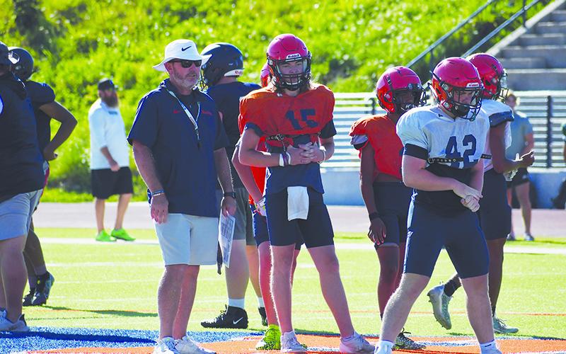 Coach Benji Harrison and quarterback DJ Pass look on as the second team lines up during padded camp. LANG STOREY/Staff