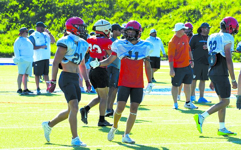 Maverick Chitwood (right) daps up Landyn Savage following a play. LANG STOREY/Staff