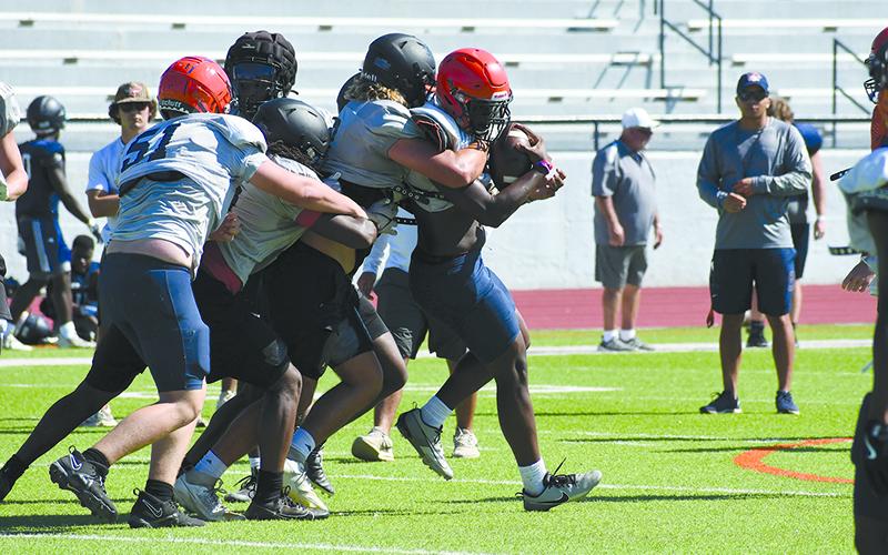 Raider ballcarrier Antonio Cantrell is met at the line of scrimmage by a bevy of Morgan County defenders. LANG STOREY/Staff
