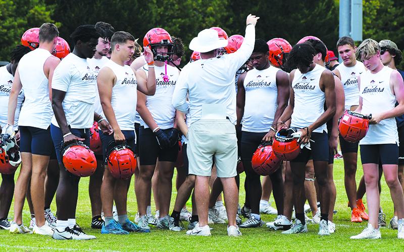 Coach Benji Harrison breaks it down with his team after the Raiders won a 7-on-7 game Wednesday. LANG STOREY/Staff