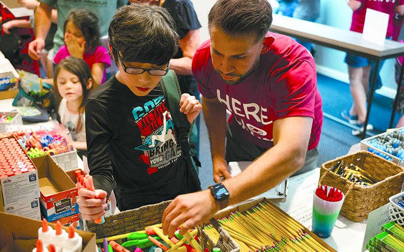 Niko Andrade (right) helps Daniel Arriaga pick the best color highlighters for his upcoming school year at last year’s Back to School Bash in Baldwin. ZACH TAYLOR/Special