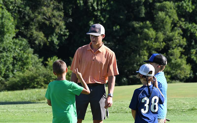 Counselor Brady McFarlin addresses his group of campers before a drill at golf camp this week. LANG STOREY/Staff