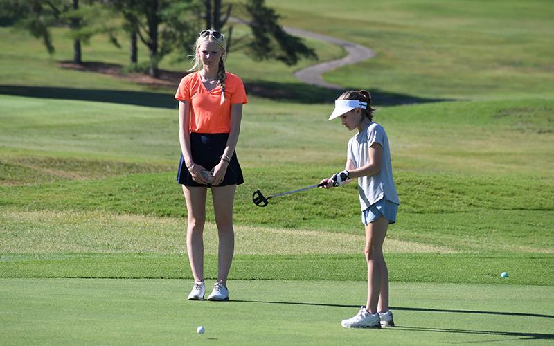 Lady Raider golfer Addie Maney looks on as Claire Stephens sends a lag putt up the 18th green during Tuesday morning’s camp session. LANG STOREY/Staff