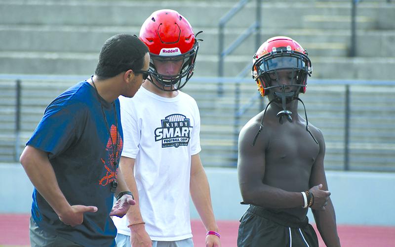 Coach Isaiah Murphy talks it up with Drake Roland (center) and Tylon Davis. LANG STOREY/Staff