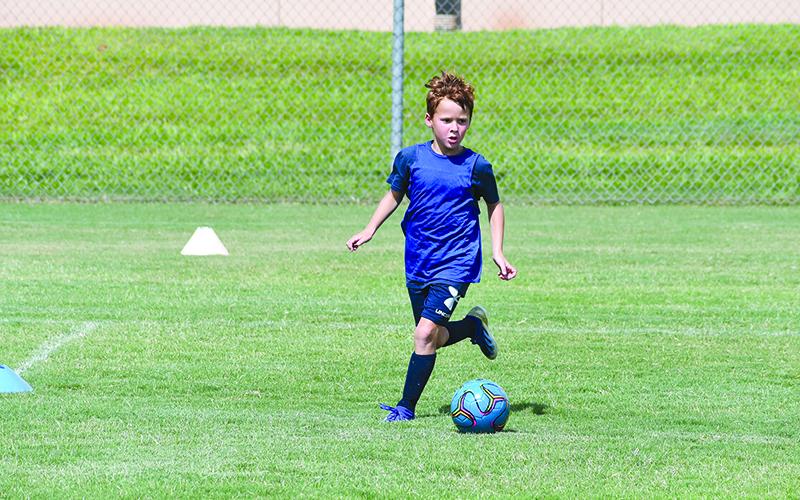 Finley Franklin pushes the ball upfield during a scrimmage game at Raider Soccer camp.