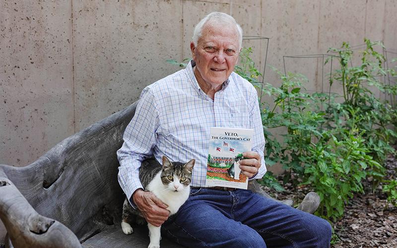 Deal sits with real-life Veto and a copy of his new book. COURTESY OF ANDREA HUDSON