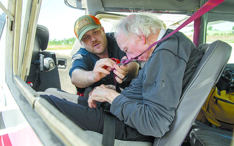 Fritchman buckles the shoulder straps for McNamara before his flight. ZACH TAYLOR/Staff