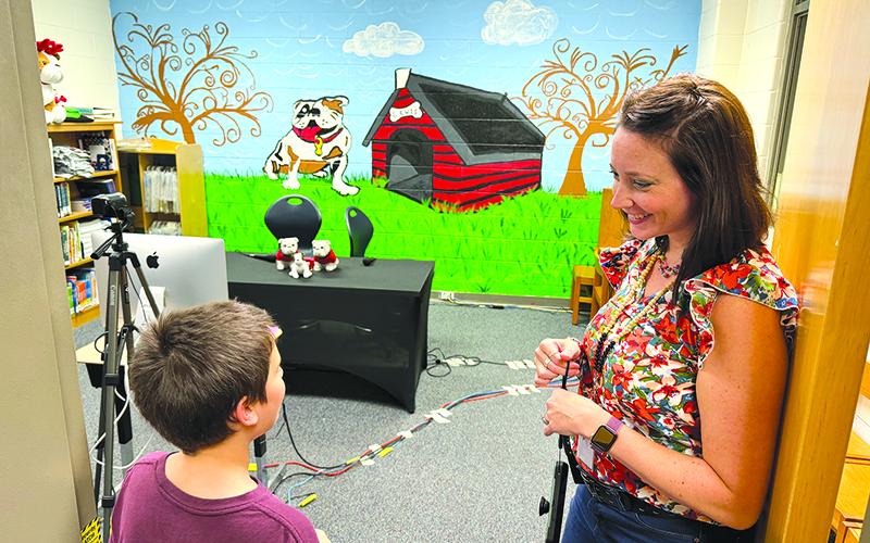 Ollie Osborne talks with media specialist Annabelle Wiley about Level Grove Elementary’s Bulldog Broadcast, which is run by fifth graders with staff supervision, at the school’s open house Wednesday. MATTHEW OSBORNE/Staff