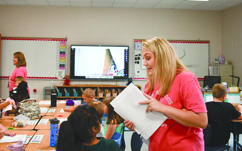 Clarkesville Elementary teacher MaKensie Barrs passes out worksheets to her second grade class on the first day of school. JULIANNE AKERS/Staff