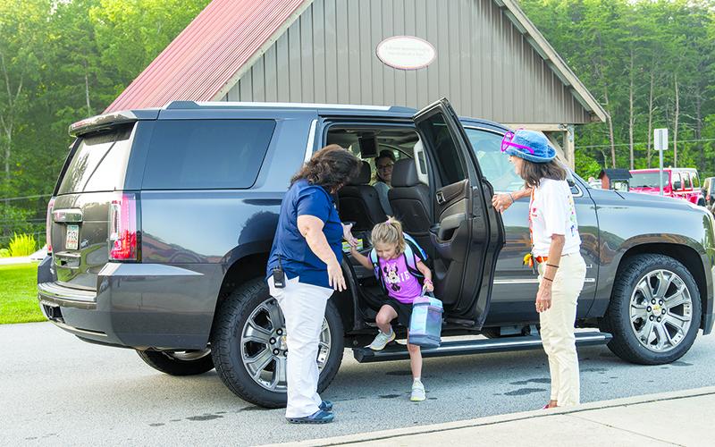 Woodville Assistant Principal Joy Phillips and Counselor Nancy Cathcart help Amelia Speed out of the car for her first day of 1st grade at Woodville Elementary School. ZACH TAYLOR/Special
