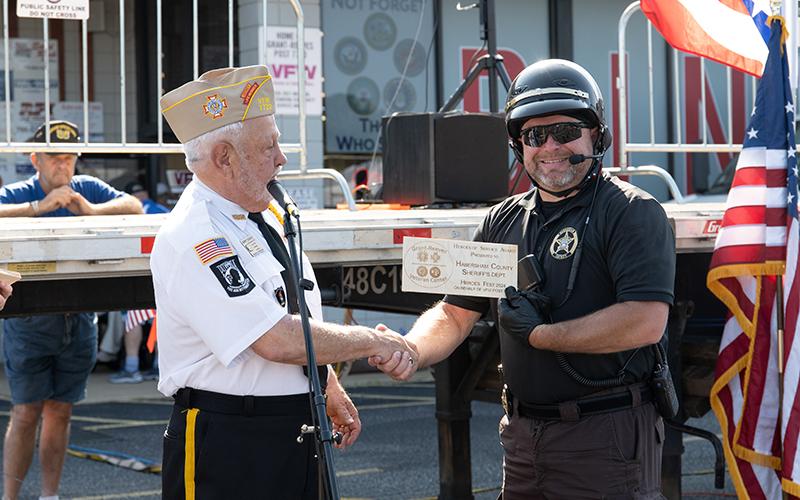 VFW Post 7720 Commander Barry Church hands Aaron Autry a Heroes of Service Award during the opening ceremony of Heroes Fest on Saturday.  ZACH TAYLOR/Staff