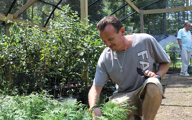 Jonathan Twitty tends to saplings at Victory Home. BRIAN WELLMEIER/Staff