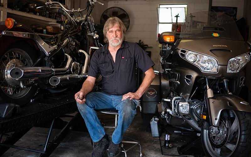 Kenneth Pardue sits beside motorcycles in his shop, Rooster’s Cycles. ZACH TAYLOR/Staff
