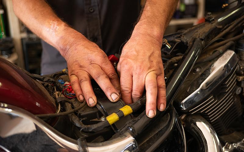 Working hands search for battery mounting screws. ZACH TAYLOR/Staff