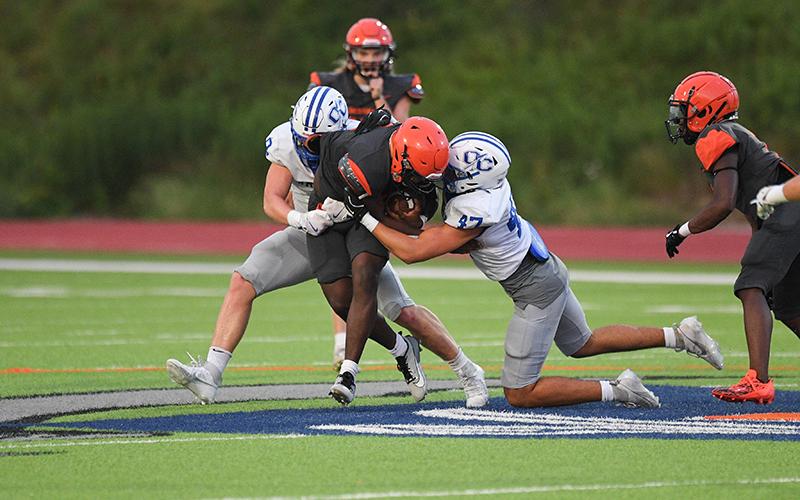 Antonio Cantrell bulldozes through a pair of Oconee defenders during the season-opening scrimmage 2 weeks ago. TOM ASKEW/Special