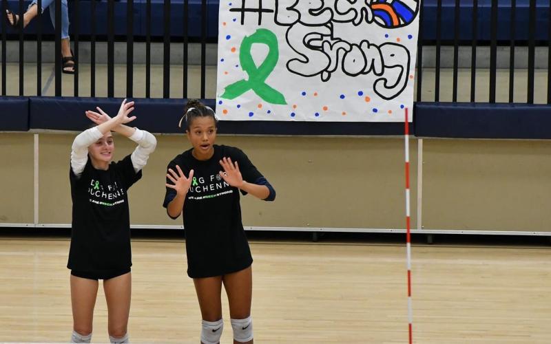 Habersham’s Maci Williams (left) and McKenzie King warmup in shirts honoring the cause last Thursday night in Mt. Airy. LANG STOREY/Staff