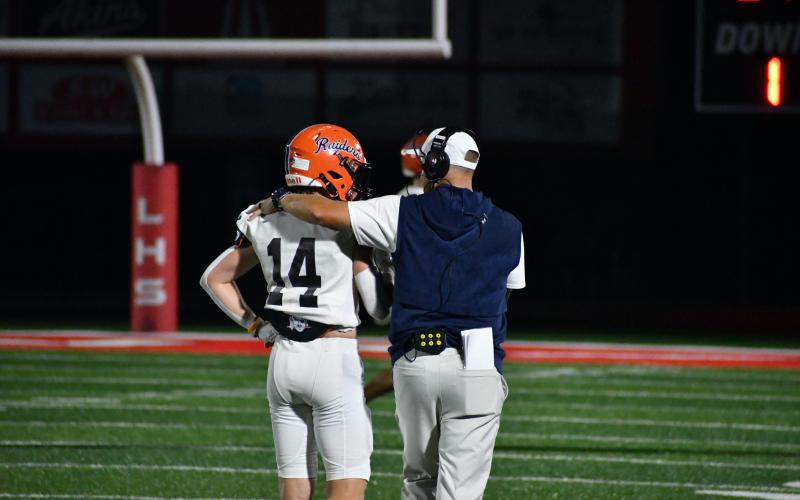Raiders defensive back Sawyer Burgess talks it up with Assistant Coach JR Robinson during Habersham's game Friday night. LANG STOREY/Staff