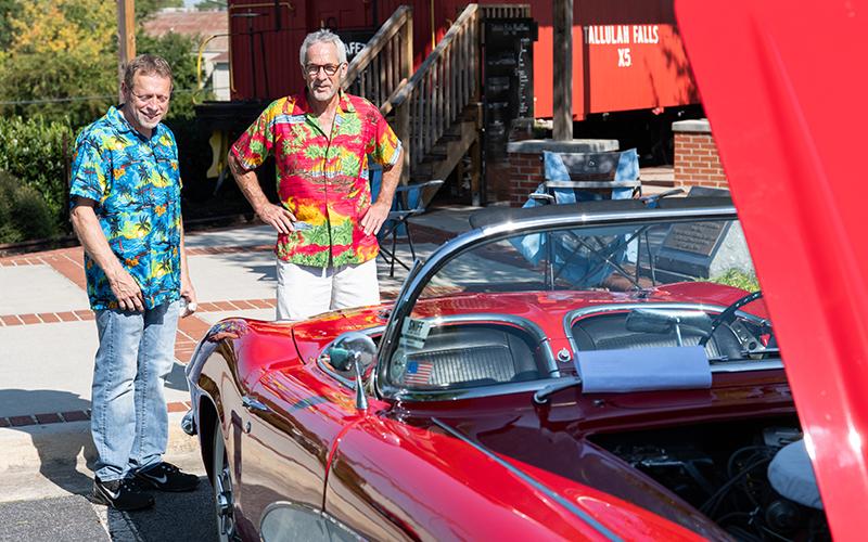 Darryl Tallent and Tim Skelton don Hawaiian shirts while looking at a 1961 Corvette. ZACH TAYLOR/Staff