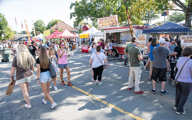 Folks gather in the food court area to enjoy a variety of foods during the festival. ZACH TAYLOR/Staff