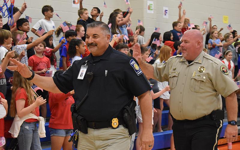 Director of School Safety Murray Kogod and Sheriff-elect Robin Krockum wave to kids at Fairview Elementary on Wednesday. JULIANNE AKERS/Staff