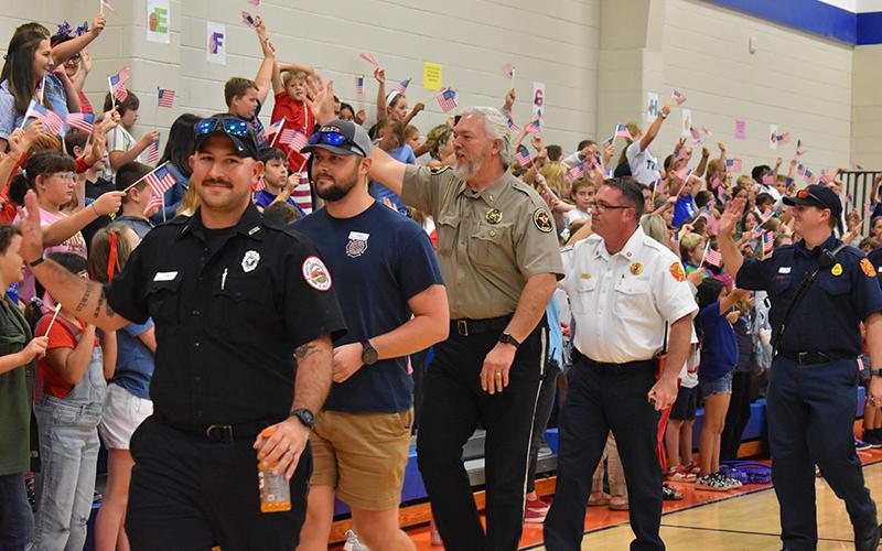 Local first responders wave to students at Fairview. From left, Kenneth Puzio and Will Sexton with White County EMS, Habersham County Sheriff Joey Terrell, Cornelia Fire Marshal Josh Hazle and Cornelia Firefighter Chris Bruce. JULIANNE AKERS/Staff