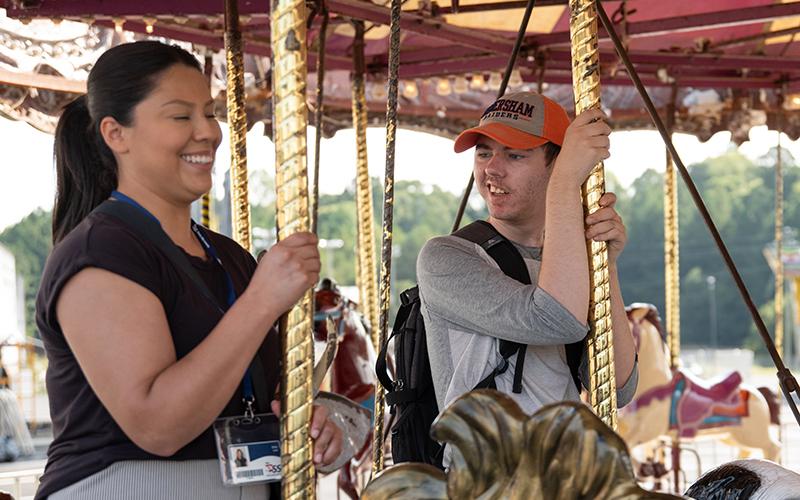 Ethan Baird rides the carousel alongside substitute teacher Erika Lara (left). ZACH TAYLOR/Staff