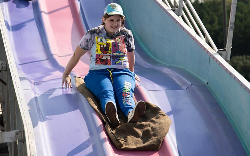 Nikki Sullens slides down the ‘Fun Slide’ at the fair on Tuesday. Sullens was seen with a smile on her face throughout the day. ZACH TAYLOR/Staff