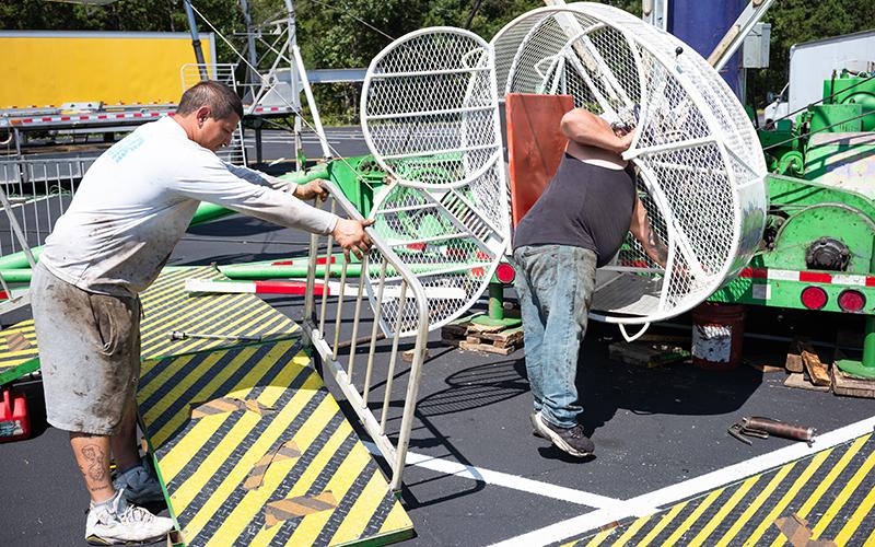 Doug Thompson and Salvador Zavala install the platforms and huge bolts that hold the seat to the ride. ZACH TAYLOR/Staff