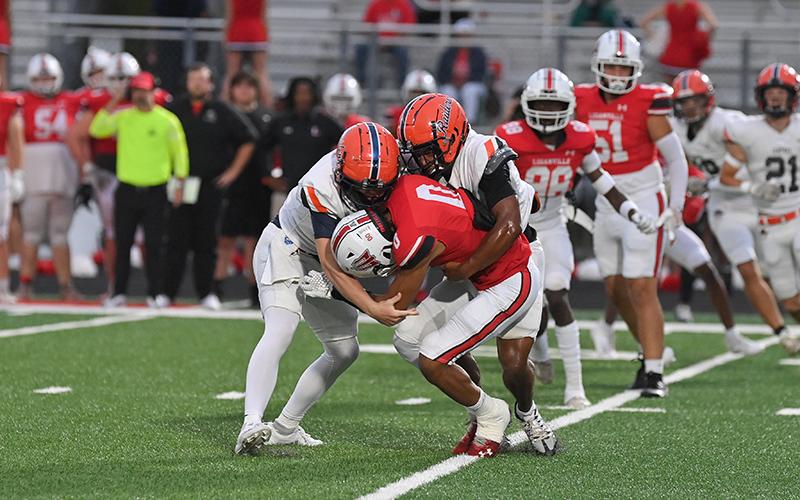 Jackson Adams (left) and Donnie Warren take down a Loganville ballcarrier during the Raiders’ 56-21 beatdown of the Red Devils on Friday. TOM ASKEW/Special