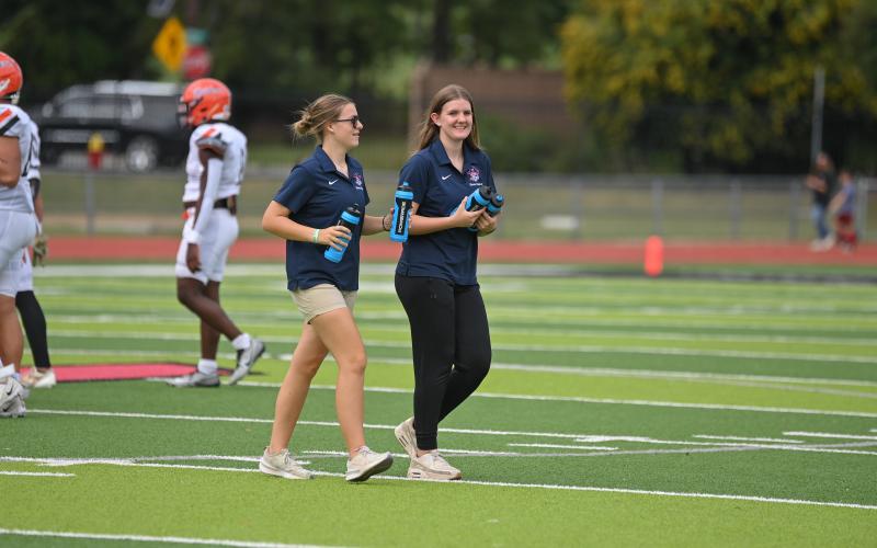Sports med students like Kristen Dean (left) and Bailey Brinson help ensure athletes are hydrated during games and practices. TOM ASKEW/Special
