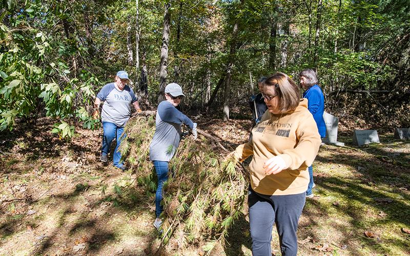 Lynn McCollum, Tiffany Teoman and Marcie Caudell move a massive pine branch that fell during last month’s storms. ZACH TAYLOR/Staff