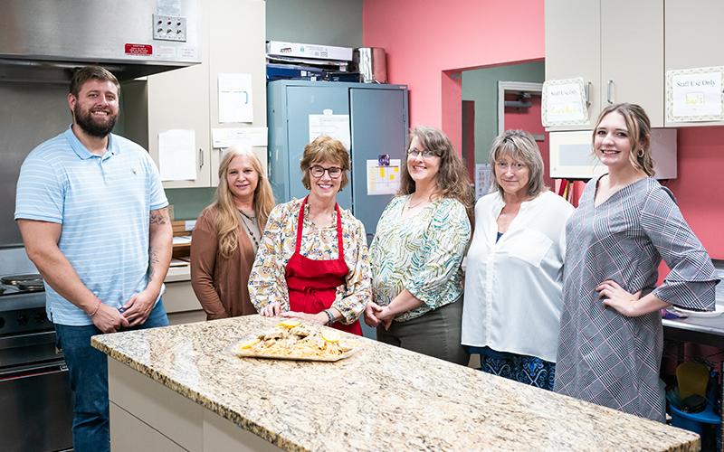 The Habersham County Senior Center team, comprised of Wellness Coordinator Mason Hall, Transportation Coordinator Cynthia Lovell, Meals on Wheels Program Specialist Inger Smith, Program Coordinator Laureen Pemberton, Senior Center Director Kathy Holcomb, and Activities Coordinator Kinsley Fowler, stands around a fresh dish prepared by Smith. ZACH TAYLOR/Staff