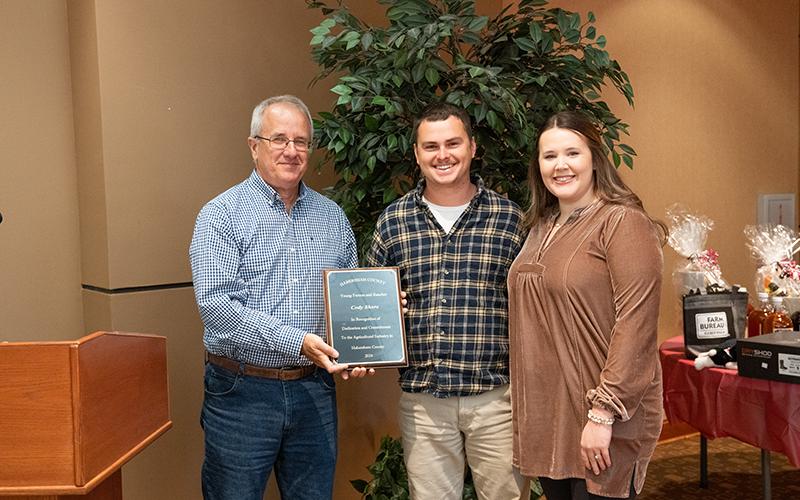 Habersham County Farm Bureau Vice President Randall Adams presents the Young Farmer and Rancher Spotlight Award to Cody Shore and his wife, Mattie. ZACH TAYLOR/Staff