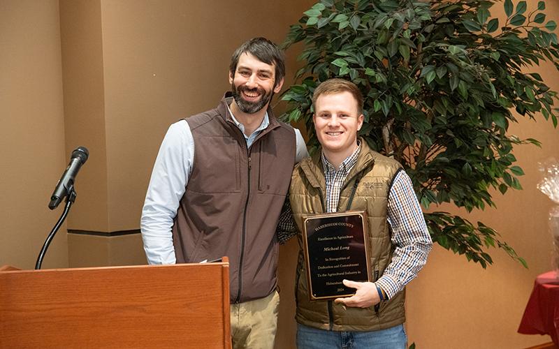 TeXga Farms’ Kyle Lewallen presents the Excellence in Agriculture Award to Michael Long. ZACH TAYLOR/Staff