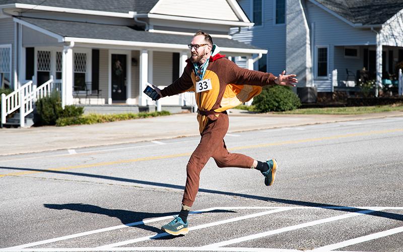 Zach Staggs played the role of the speedy turkey for the Turkey Trot on Saturday. Staggs had numbered tailfeathers that were torn off by runners along the route for gift cards and cash prizes. ZACH TAYLOR/Staff
