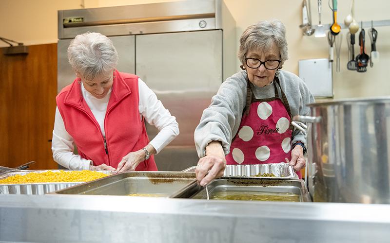 Claudia Jessup and Tina Evans work to get the most out of the corn and green bean batches. ZACH TAYLOR/Staff