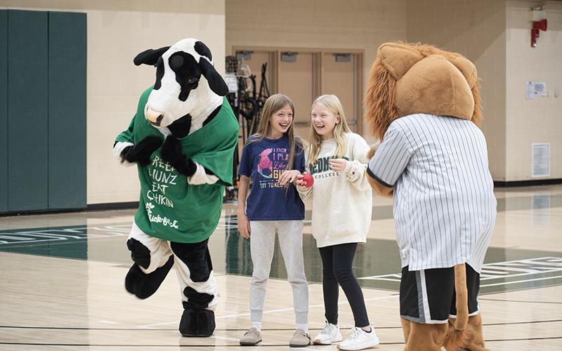 The Chick-fil-A cow, Rylee Bagwell, Genevieve Washington and Leo the Lion dance during halftime. JULIANNE AKERS/Staff