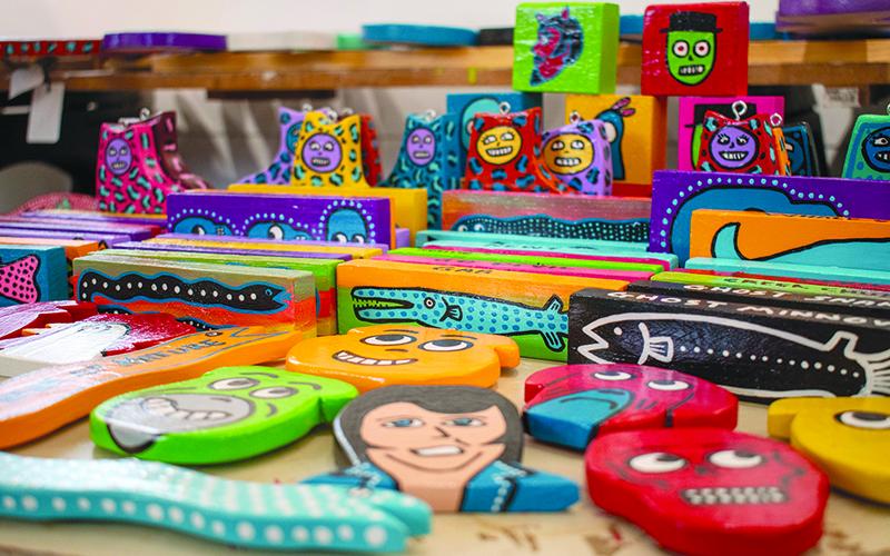 Allison creates brightly colored wood cutouts that double as Christmas ornaments and magnets. JULIANNE AKERS/Staff