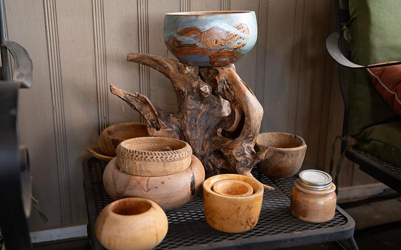 A collection of bowls and a unique root carving sit on a side table on Kenneth Adams’ front porch. ZACH TAYLOR/Staff
