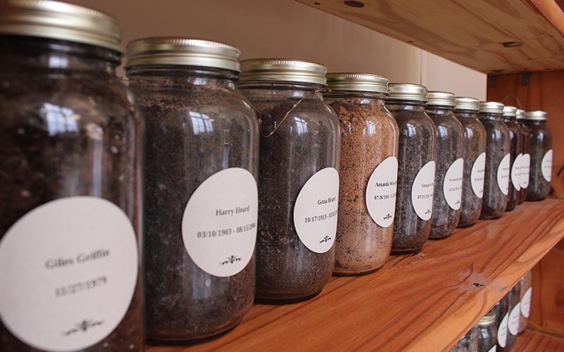 Glass jars of dirt stand in a line with stickers of the names of those who have passed, but remain in the memory of those who attend Ebenezer Baptist Church. HANNAH CAUDELL/Staff
