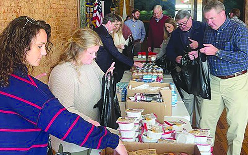 Members of the Habersham Kiwanis Club help pack bags of food for kids in the community. SUBMITTED