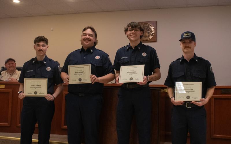 From left, Corven Parham, Ross Shelnutt, Jordon Evans, and Austin Tyler stand before a packed audience of friends and family as they roar in applause upon their official graduation and recruitment into the Baldwin Fire Department. HANNAH CAUDELL/Staff