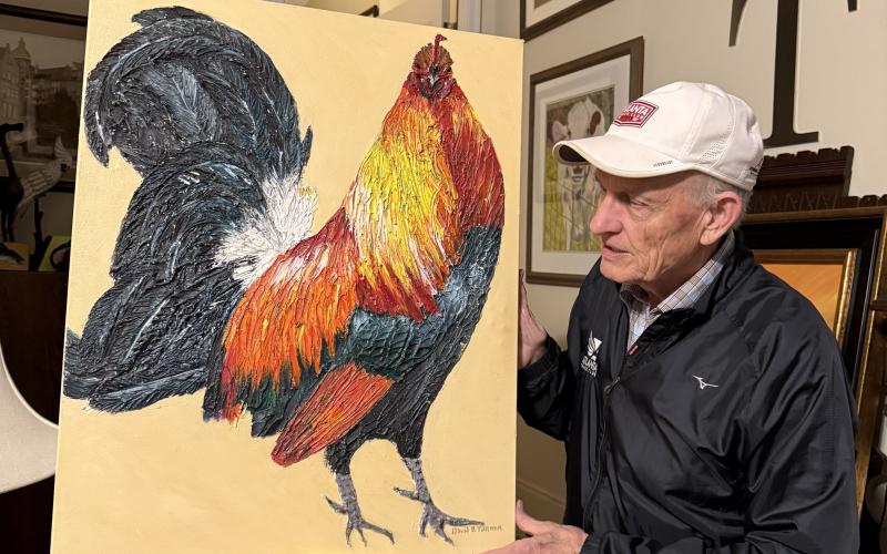 David Turner holds up a painting he recently completed. LANG STOREY/Staff