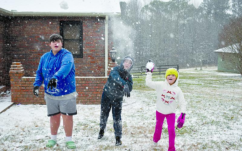 Camron Parker, Brett Cantrell and Breckyn Cantrell play in the snow in Cornelia. SAMANTHA SINCLAIR/Staff