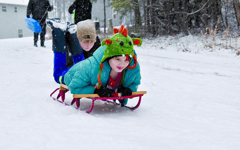 Jack Forde gives Ollie Osborne a push on his sled Friday morning. SAMANTHA SINCLAIR/Staff