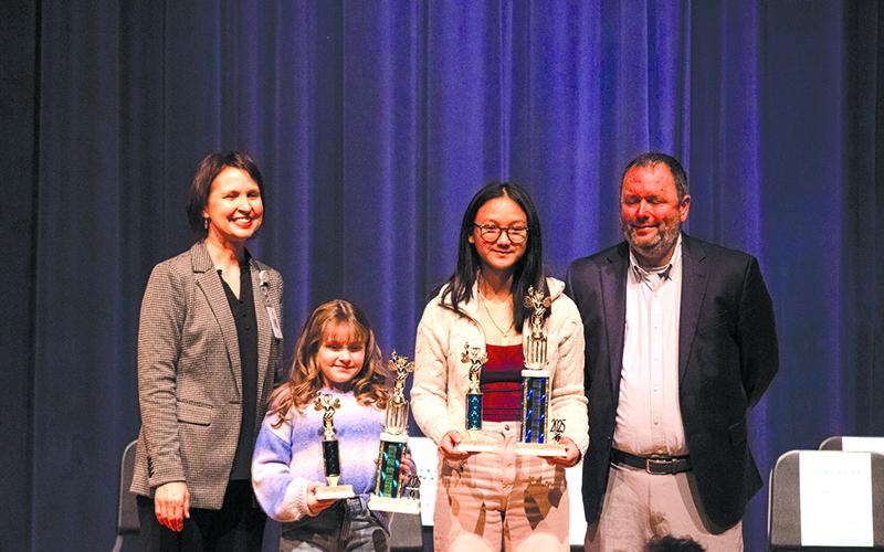 From left, Director of Elementary Schools Dr. Susan Davis,  Woodville Elementary School student Wiley Colston, Hilliard A. Wilbanks Middle School student Khamla Laosalie, and  Assistant School Superintendent Patrick Franklin stand on the stage after the Habersham County School System spelling bee competition for photos. Laosalie won first prize after multiple rounds, and Colston earned the runner-up spot. HANNAH CAUDELL/Staff