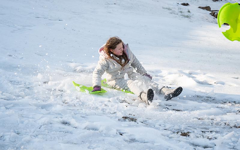 London Grant holds on to a piece of her broken sled while flying down a hill. ZACH TAYLOR/Staff